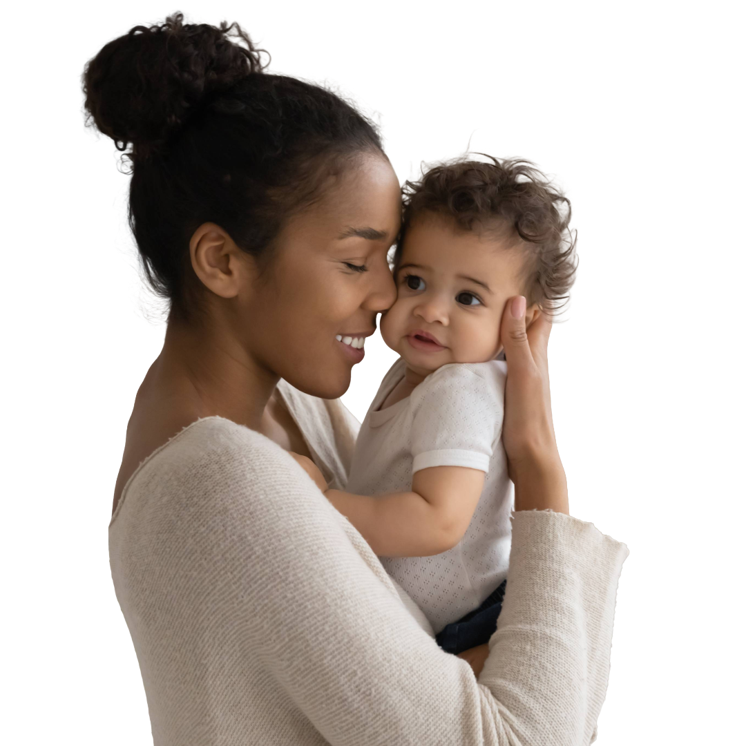 Mom with air bun nuzzles baby in her arms..