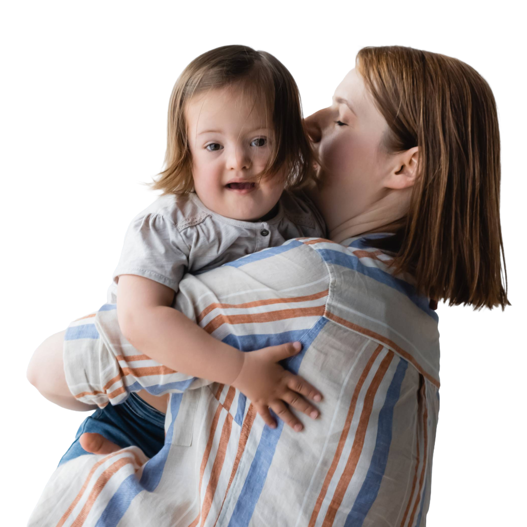 Mom holds her toddler who has Downs Syndrome.