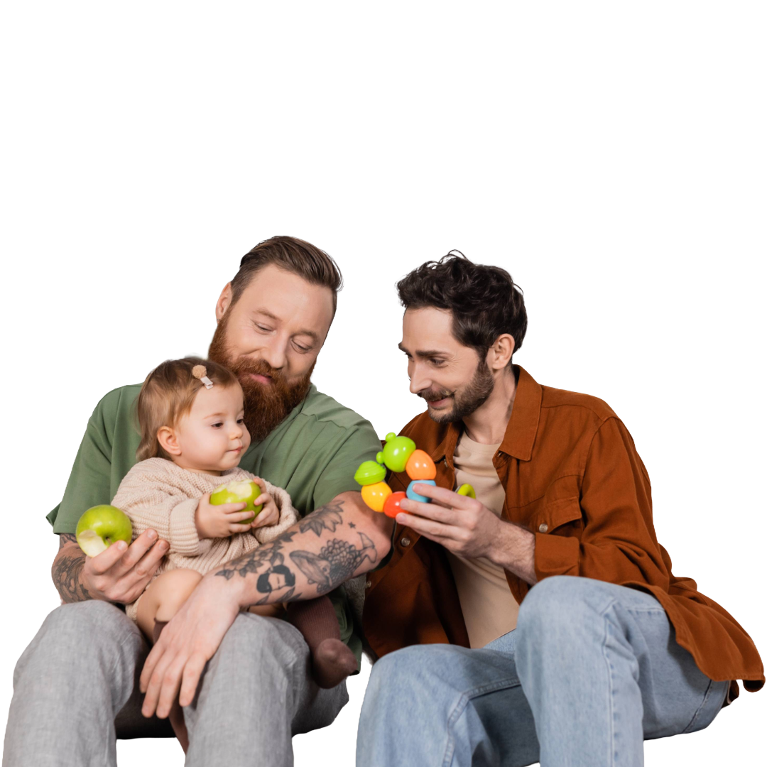Baby and her two dads enjoy eating apples and looking at baby toy.