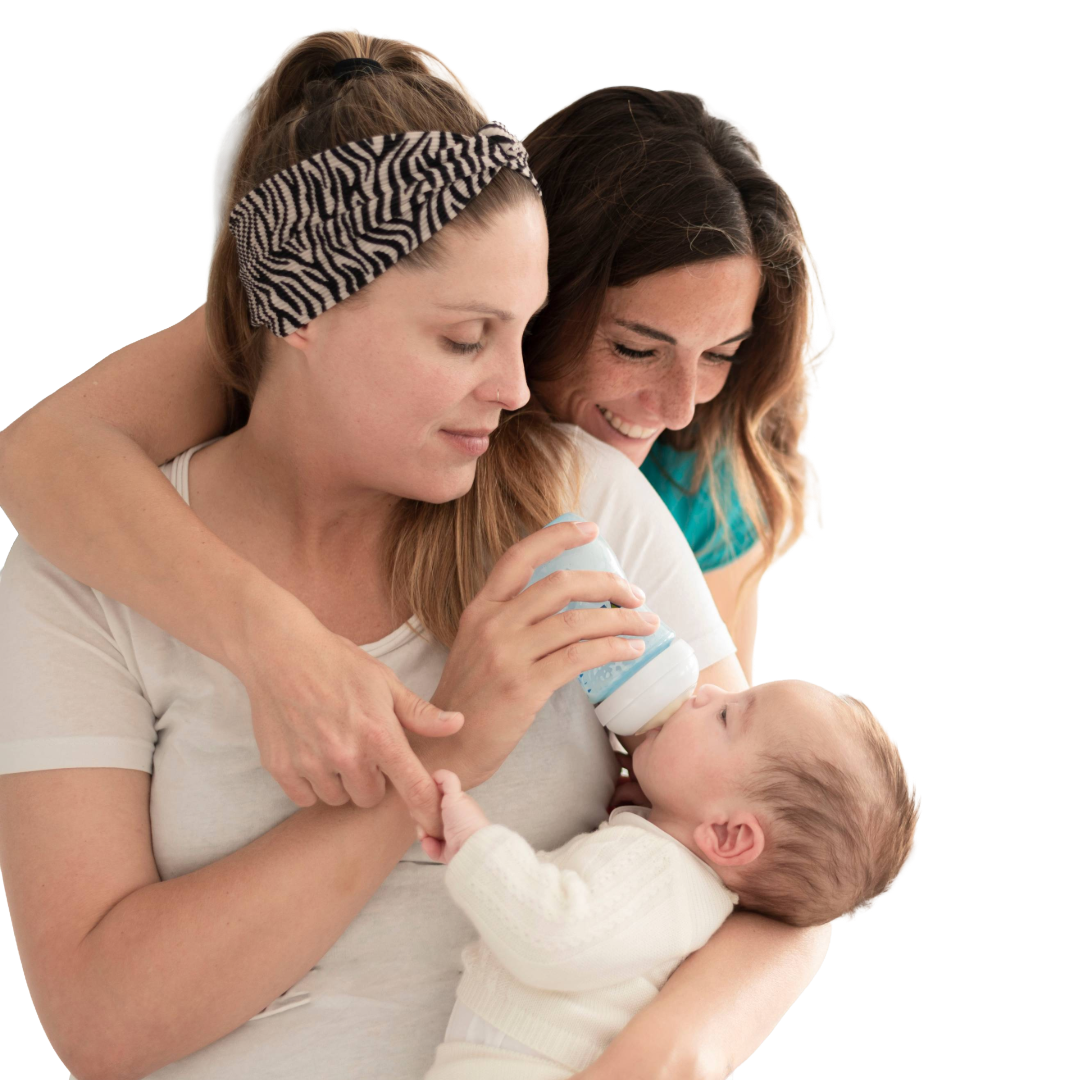 Infant is held by two moms while taking a bottle.
